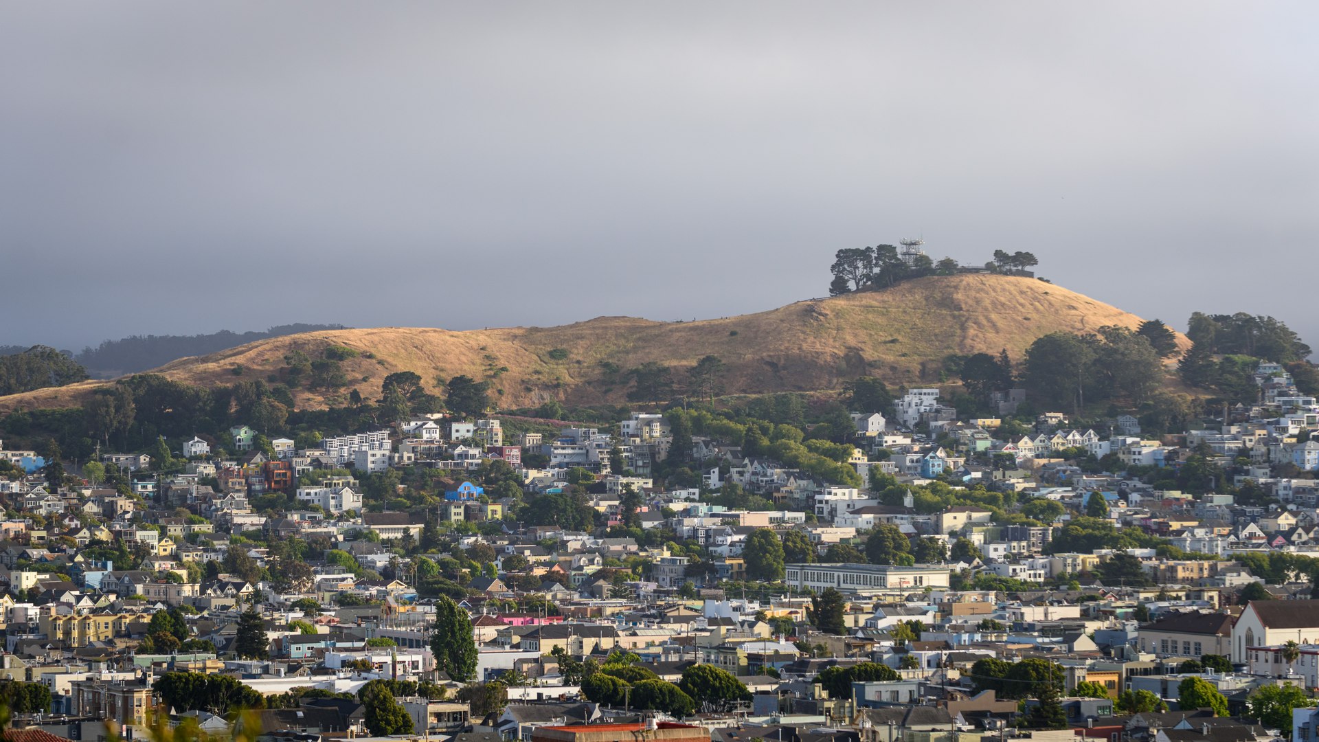 Bernal Hill in San Francisco with houses climbing its slopes and the microwave tower on top, seen from Potrero Hill
