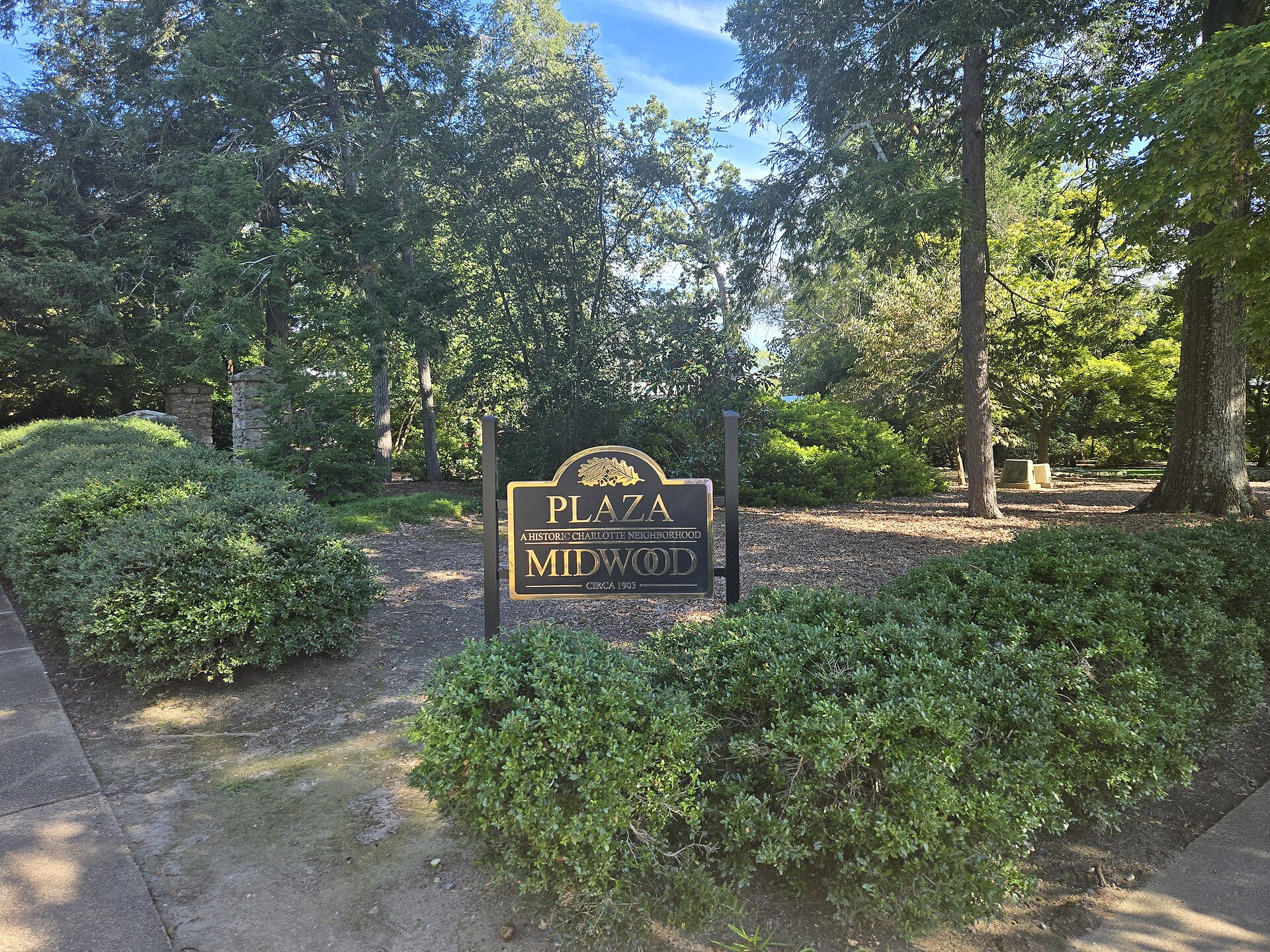The Plaza Midwood neighborhood sign at Belvedere Avenue and The Plaza in Charlotte, with the VanLandingham Estate pillars behind it